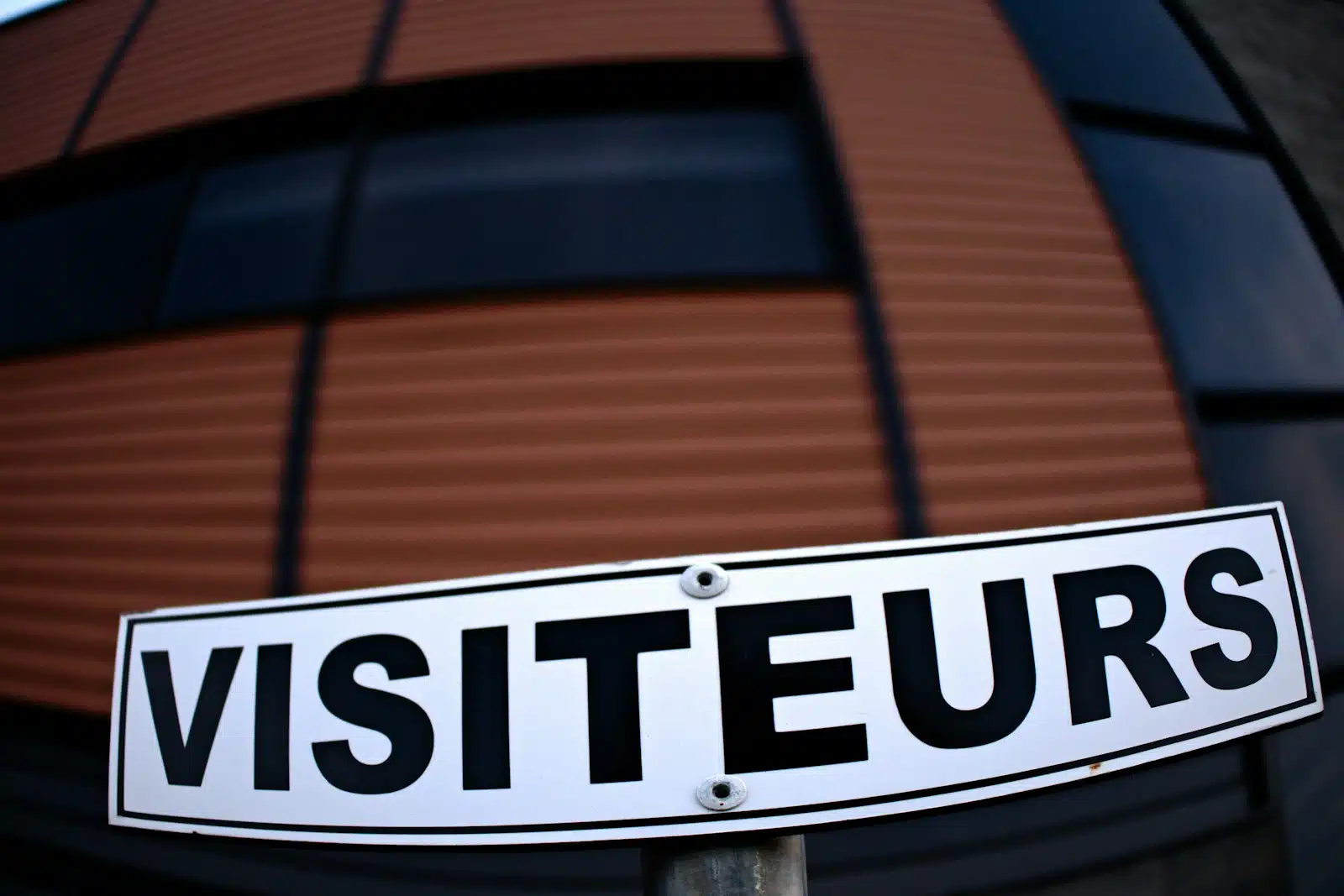 a white street sign sitting in front of a building